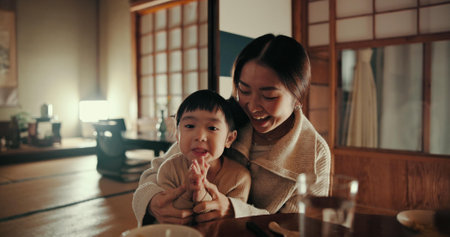 Food, home and Japanese mother and child at table for lunch, breakfast and eating meal together. Happy family, culture and mom and young girl in traditional house for bonding, relationship and loveの写真素材