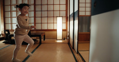 Happy, home and Japanese girl in a family house running for game, fun and playing. Young child,...
