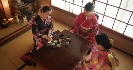 Japanese, women and kimono for tea ceremony in Chashitsu with matcha or custom tradition. People, temae and vintage style dress or top view for culture, fashion and honor with antique crockeryの写真素材