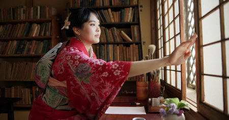 Open window, Japanese and woman with architecture, apartment and morning with culture. Library, calm and zen with sliding door, female person and traditional dress with accommodation in Tokyoの写真素材