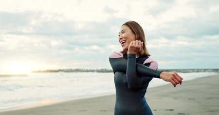 Surfer, beach and woman with stretching, funny and vacation with getaway trip, workout and training. Person, holiday and Japan with ocean, waves and exercise with warm up, muscle and wellnessの写真素材