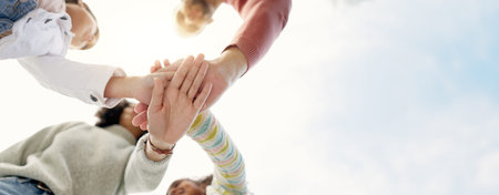 Family, hands together and team in solidarity below for collaboration or celebration under sky. Low...