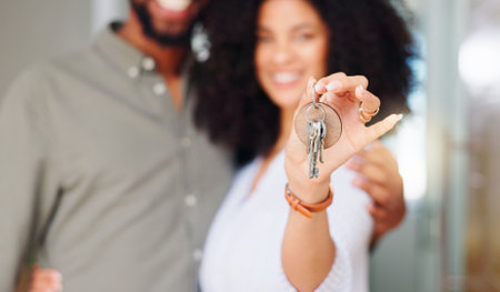 Couple, hand and keys at front door, new home and portrait with pride, care and bonding. African woman, man and happy together with embrace, love and investment with property, real estate or houseの写真素材