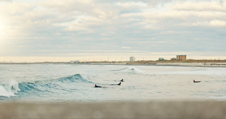 Sea, exercise and people surfing at beach on blue sky for fitness, health or recreation in summer....