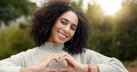 Face, smile and woman with heart hands, outdoor and support with emoji, kindness and wellness....
