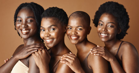 Face, beauty and smile with black woman friends in studio on a brown background for natural wellness. Portrait, skincare and happy with a group of people looking confident at antiaging treatmentの写真素材