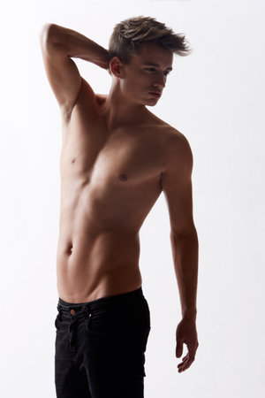 Topless, natural and masculine with body of man in studio on white background for health or wellness. Aesthetic, skin or stomach and young shirtless model in jeans for hygiene and satisfactionの写真素材