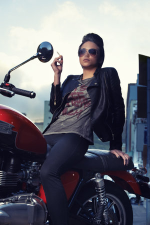 Motorcycle, cigarette and woman smoking in city for travel, transport or road trip as rebel....