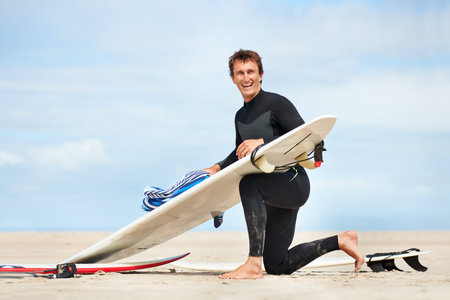 Surfer, man and portrait with surfboard on beach with wetsuit, blue sky and cleaning with mock up...