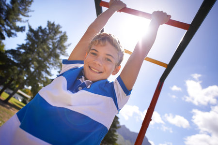 Child, monkey bars and park in portrait, smiling and energy at obstacle course on outdoor adventure. Happy male person, active and exercise on jungle gym, boy and fitness on playground in Australiaの写真素材