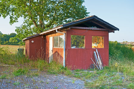 Countryside, grass and field with broken cabin with vintage architecture on neighborhood in Texas. Ghost town, countryside and house with rust in quiet community with nature and woods in villageの写真素材