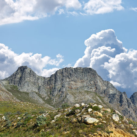 Mountain, blue sky and travel location with clouds, summer and journey in natural landscape. Landmark, nature and environment for outdoor adventure, explore and holiday destination in South Africa.の写真素材