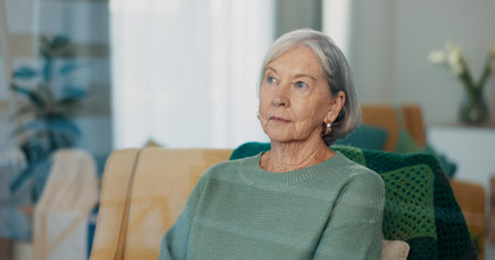 Thinking, face and senior woman on couch with dementia, memory loss and Alzheimer in nursing home....