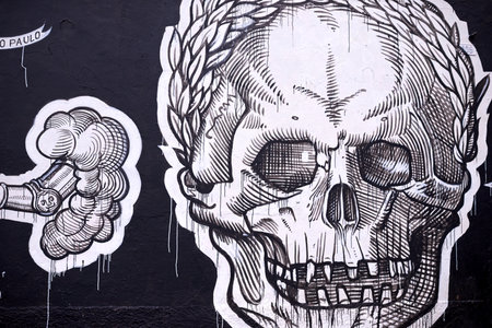 Graffiti, painting and wall mural in neighborhood with skull illustration and creativity in the city. Urban, art and black and white on a street with drawing in Sao Paulo outdoor with design tagの写真素材