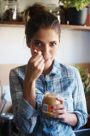 Person, jar and peanut butter with kitchen, portrait and energy with spread for health and wellness....