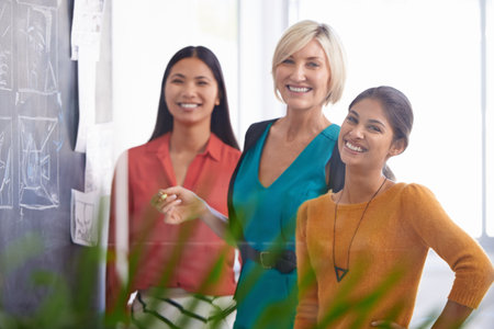 Creative woman, portrait and team with chalkboard for storyboard, development or planning at office. Female person or group of employees with smile for project, production or startup at the workplaceの写真素材
