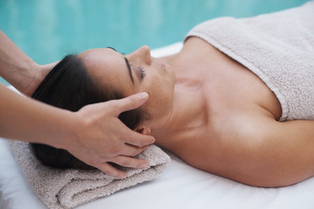 Hands, skincare and woman by pool for massage at spa, health and wellness for zen, therapy or peace. Female person, lady and relax for wellbeing, body and tranquil on table, calm and naturalの写真素材