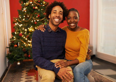 Couple, portrait and Christmas holiday at tree in apartment for bonding celebration with decoration, connection or lights. Man, woman and face in living room for festive season, gifts or marriageの写真素材