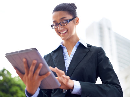 Lawyer, smile or woman with tablet in city for legal research, online app or social media post. Attorney, low angle or happy advocate reading business email, networking or internet article for travelの写真素材