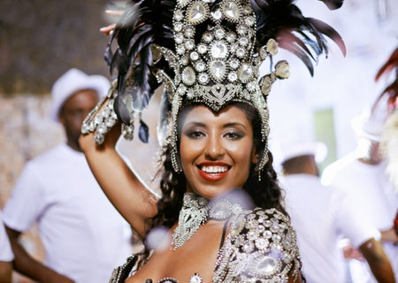 Portrait, happy woman and dancer at carnival with band for performance, party or celebration. Face, samba and Brazilian person at music festival in feather costume, makeup and smile at concert eventの写真素材