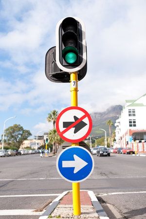 Road sign, traffic light and signage in street for direction with attention notification and arrow symbol outdoor in city. Board, public notice and signpost for route, alert message and advertisementの写真素材