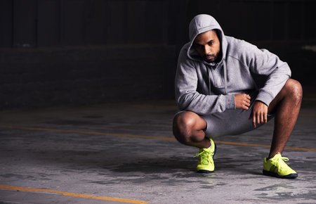Fitness, serious and man with hoodie in parking lot for exercise, training and intense workout....