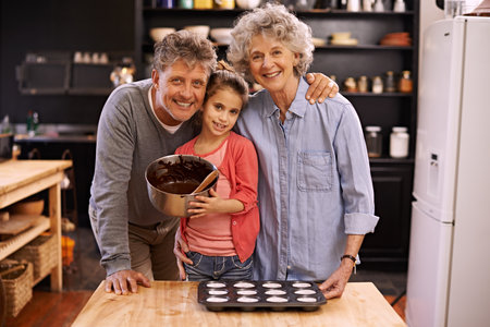 Portrait, grandparents and girl in a kitchen, baking and ingredients for hobby and bonding together. Face, old man or senior woman with grandkid or child development with recipe, fun or weekend breakの写真素材