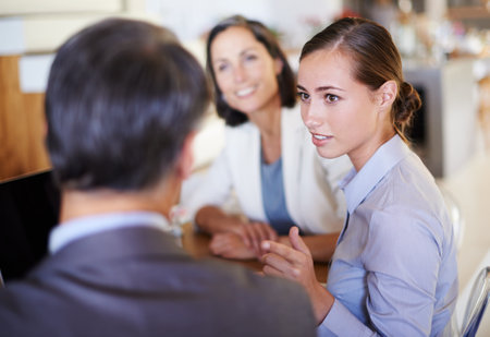 Teamwork, talking or business people in meeting, conversation or discussion in boardroom or office. Listening, colleagues speaking or employees planning for support, feedback report or group projectの写真素材