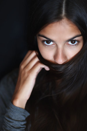 Portrait, cover mouth and woman with hair care, wellness and volume on dark studio background. Face, person and model with shampoo or clean scalp with cosmetology or beauty with treatment or groomingの写真素材
