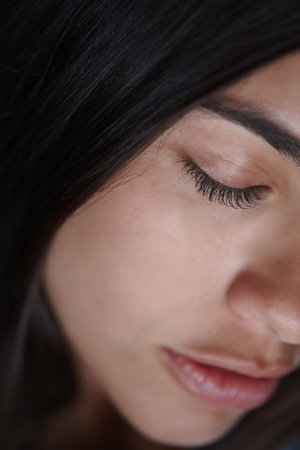 Woman, beauty or face closeup in studio for skincare, spa or cosmetology for natural shine or clean skin. Cosmetics, eyes closed or girl with glow, dermatology results or wellness on black backgroundの写真素材