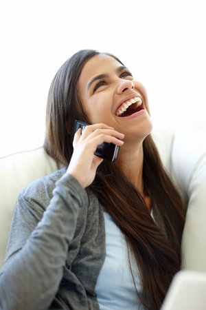 Phone call, funny and laughing woman, smartphone and couch at home for relax. Joke, comic and conversation on cellphone or technology for social female person, mobile networking or humour on sofaの写真素材