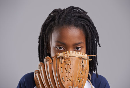 Sports, baseball and portrait of child on gray background with glove for training, practice and match. Fitness, youth and young boy with equipment for exercise, playing games and pitch in studioの写真素材