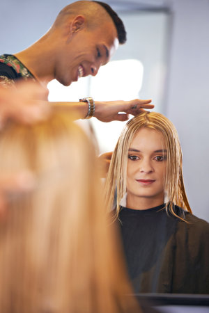 Woman, hairstylist and hair care in salon, mirror and keratin treatment or dye for grooming. Female person, beauty professional and makeover transformation at hairdresser, cosmetics and pamper clientの写真素材
