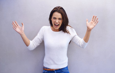 Excited, hands and portrait of woman with success for achievement, giveaway winner and celebration by wall. Happy, face and female person with surprise emoji for announcement, good news or discountの写真素材