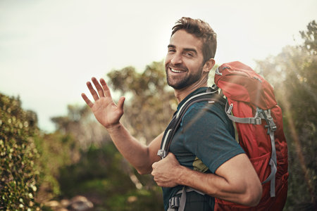 Man, hike and hi with smile for adventure with backpack for fitness, workout and hobby in New Zealand. Portrait, happy and outdoor activity in nature for healthy mind in woods on holiday in summerの写真素材