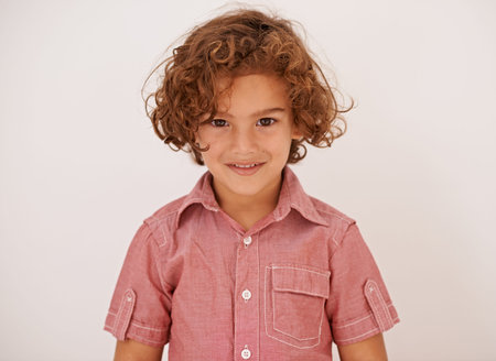 Smile, fashion and boy child in studio with casual, trendy and cool shirt for outfit with curly...