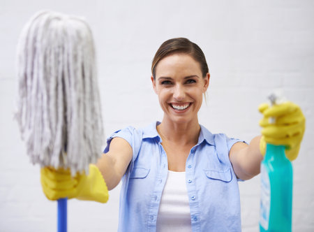 Mop, spray and portrait of woman in bathroom, cleaning home or hotel with smile. Housework, mission and girl, housekeeper or happy cleaner service washing dirt, germs and sanitation in apartmentの写真素材