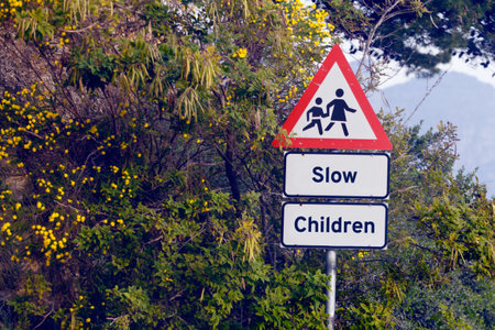 Road sign, pedestrian and slow children with mistake for grammar, joke and comic text for walking in neighborhood. Asphalt, error and funny signage with graphic, language and wrong warning in townの写真素材