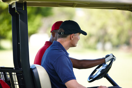 Men, friends and drive golf cart on field for exercise, sports and health on outdoor course. Male person, workout and outside for fitness, competition and golfers sit in vehicle for staying activeの写真素材
