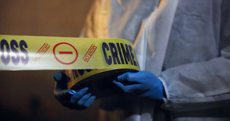 Police, hands and yellow tape for crime scene, investigation and barricade in night for warning,...