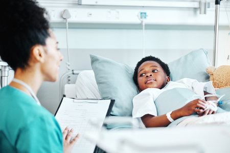 Clipboard, doctor and child in bed at hospital for recovery of surgery, illness or medical diagnosis. Healthcare, consultation and female pediatrician talking to African kid patient resting in clinicの写真素材