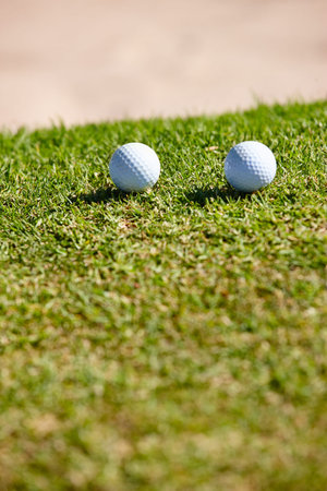 Golf ball, grass and closeup for sports, play and hobby for recreation in summer outdoor. Equipment, round and mockup on field for training, athlete and activity on green lawn for practice and gameの写真素材
