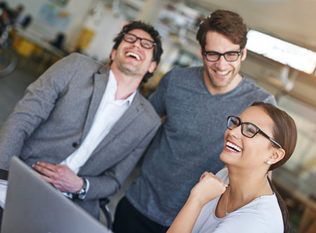Team, laptop and happiness in office with laughing, cheerful and happy for company as colleagues....