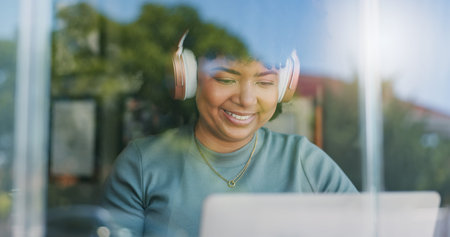 Woman, headphones and happy with laptop, remote work and streaming music playlist for online and...