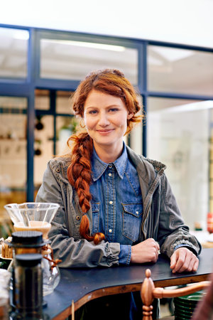 Woman, portrait and smile in morning at a coffee shop for drink, relax and order at diner for latte. Girl, person or customer in a cafeteria, restaurant or store for cappuccino, espresso or beverageの写真素材