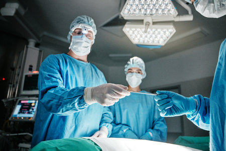 Doctors, hands and scalpel in operating room at hospital in scrubs, ppe or emergency surgery for health. Surgeon, group and together in icu, medical procedure or giving tools for wellness at clinicの写真素材
