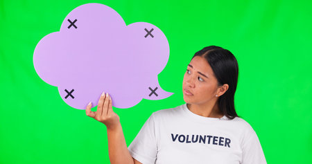 Speech bubble, green screen and volunteer fail by woman face in studio with tracking markers on mockup background. Volunteering, crisis and portrait of asian lady with poster and bad feedback reviewの写真素材