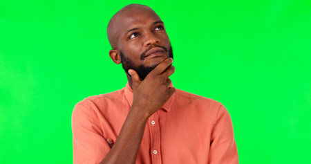 Black man, thinking and mindset on green screen, decision and brainstorming, mockup space on studio background. Ideas, thoughtful and contemplating choice, male person with question and inspirationの写真素材