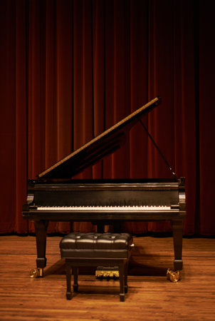 Piano, theatre and musical instrument for classic or jazz music ready for a concert or performance. Keys, curtain and isolated in a grand hall for solo or ensemble band recital with stage and chairの写真素材