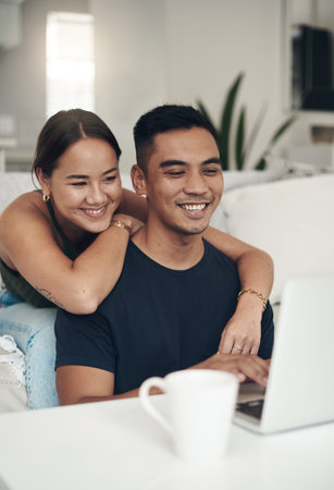 Smile, couple and remote work on laptop in home office for social media or communication. House, happy man and woman on computer at table on internet, website and freelancer embrace for love togetherの写真素材